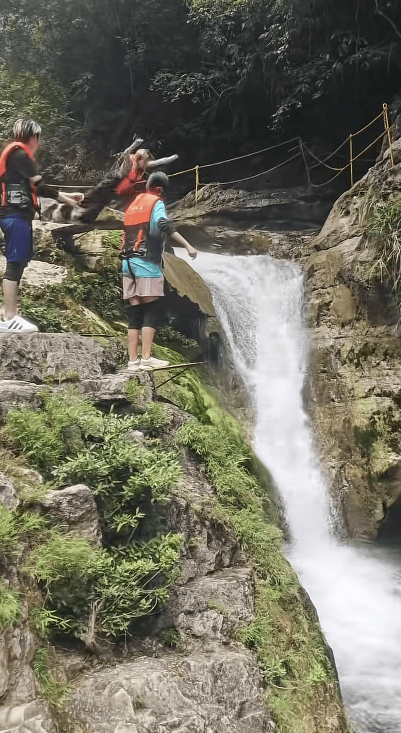 贵州一峡谷景区女子准备跳水时脚滑从跳台坠落，当事人：摔下后落入水中，人很安全；景区：跳台下为水池，池内大石头已搬走，配备有救生员
